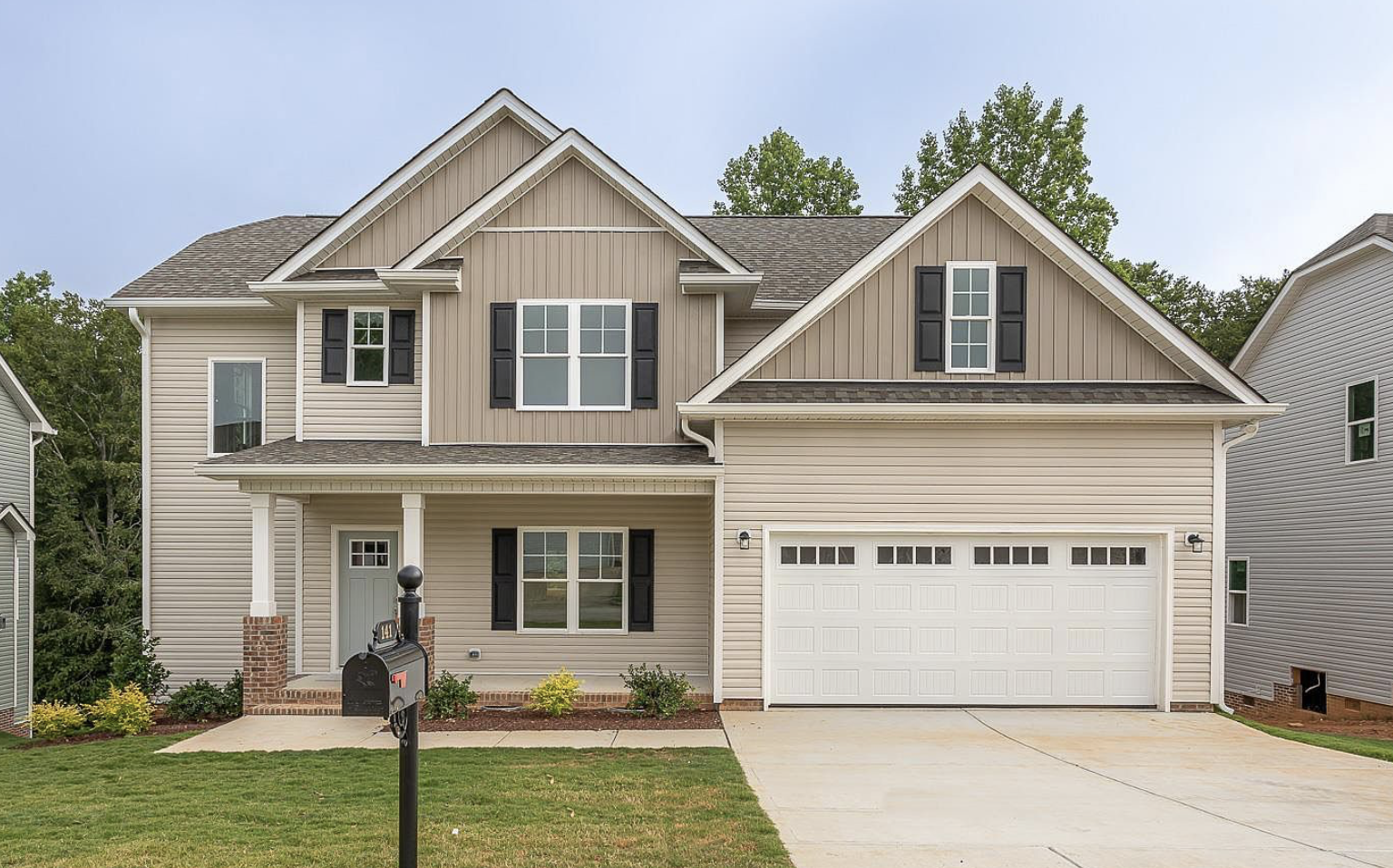 A house with two cars parked in front of it.