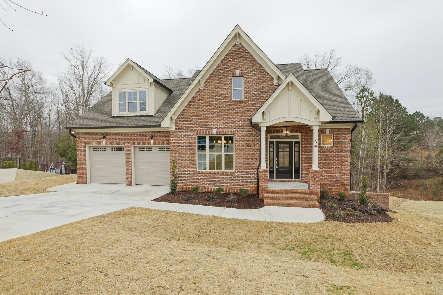 A large brick house with two garage doors.