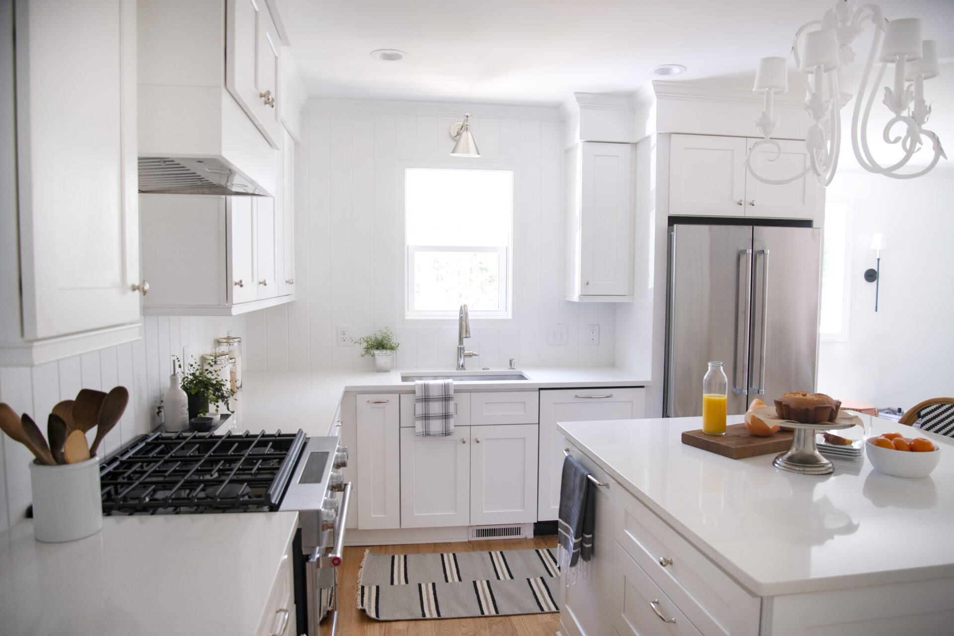 A kitchen with white cabinets and appliances in it