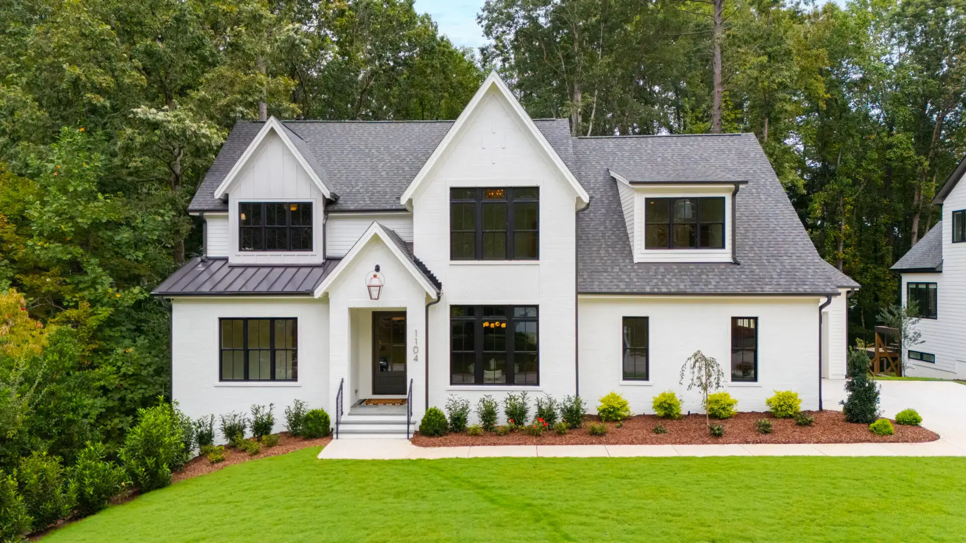 Modern white house with green lawn.