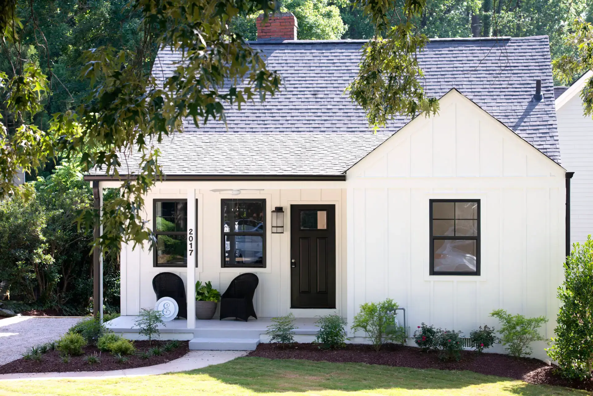 A white house with black shutters and a porch.